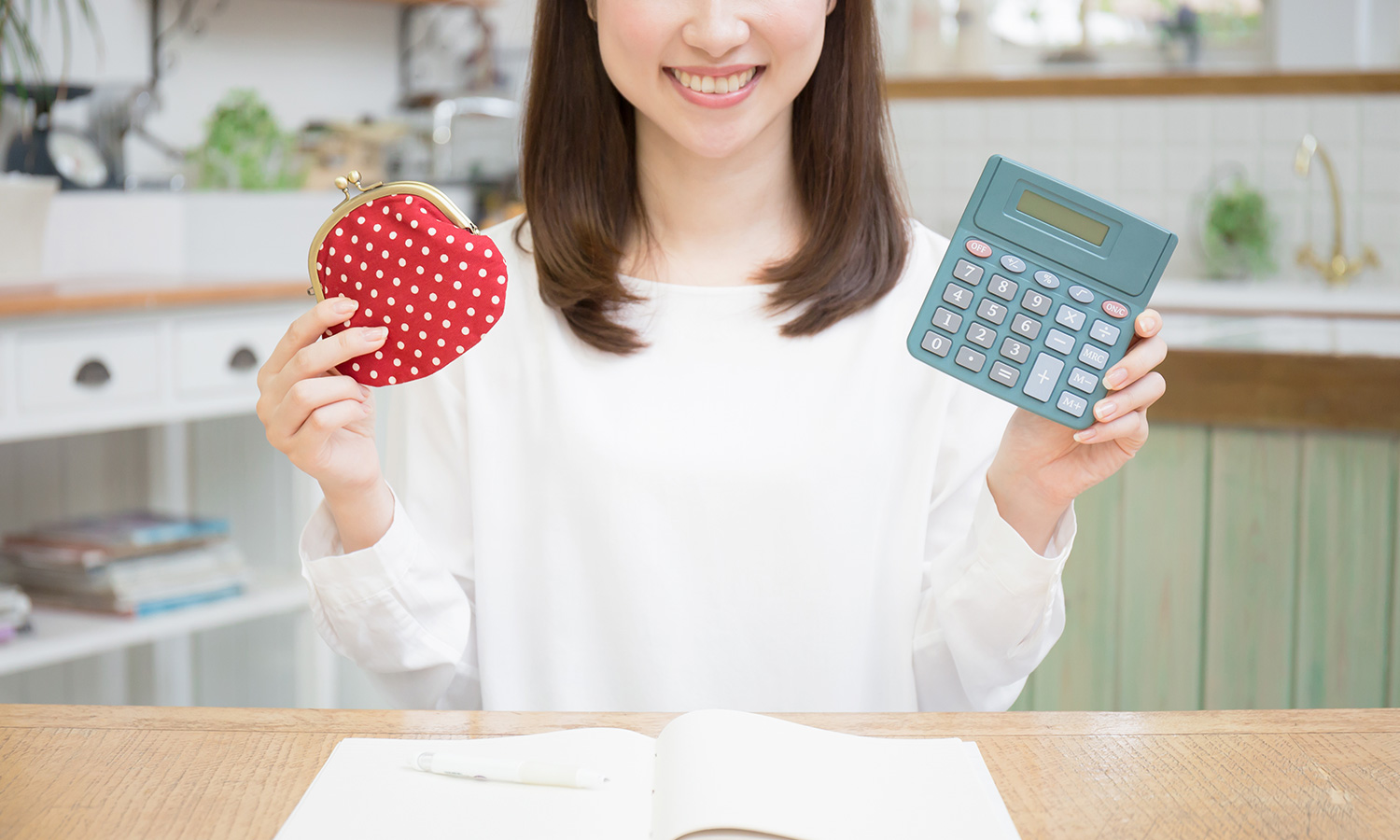 財布と電卓を持つ女性